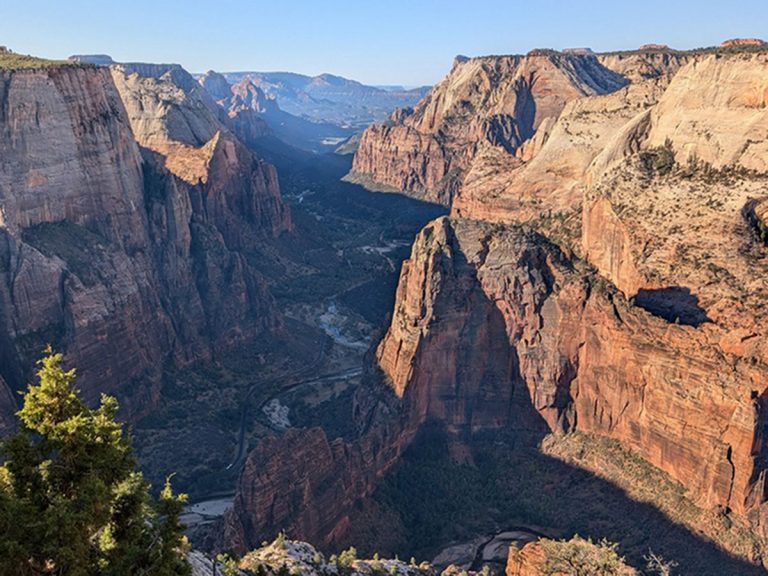 View of Zion Canyon from Observation Point. In the middle you can see the popular hike and trail for Angel's Landing. The Virgin River is running through the canyon.