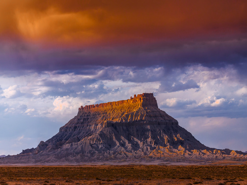 an image of factory butte in utah with a pretty sky