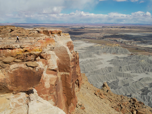 lady walking to the edge of north caineville mesa in utah. It is a scenic overlook.