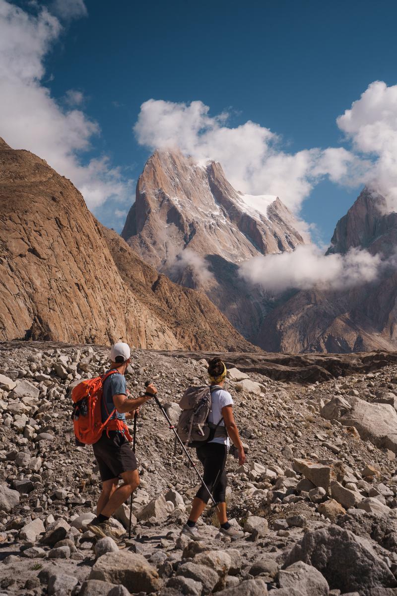 Trekkers crossing the Baltoro Glacier beneath the Trango Towers